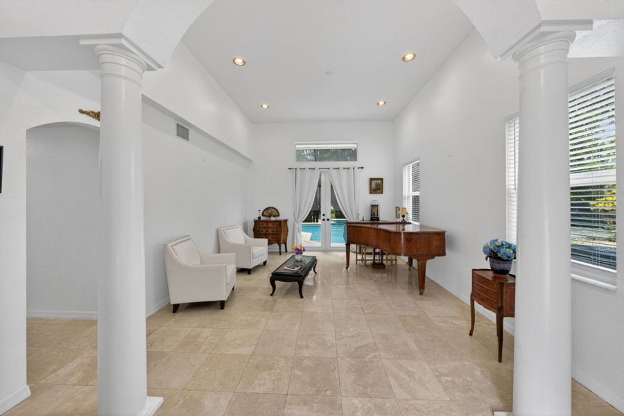 Columned living room with grand piano
